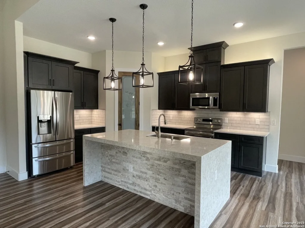 Dark cabinets with waterfall quartz island